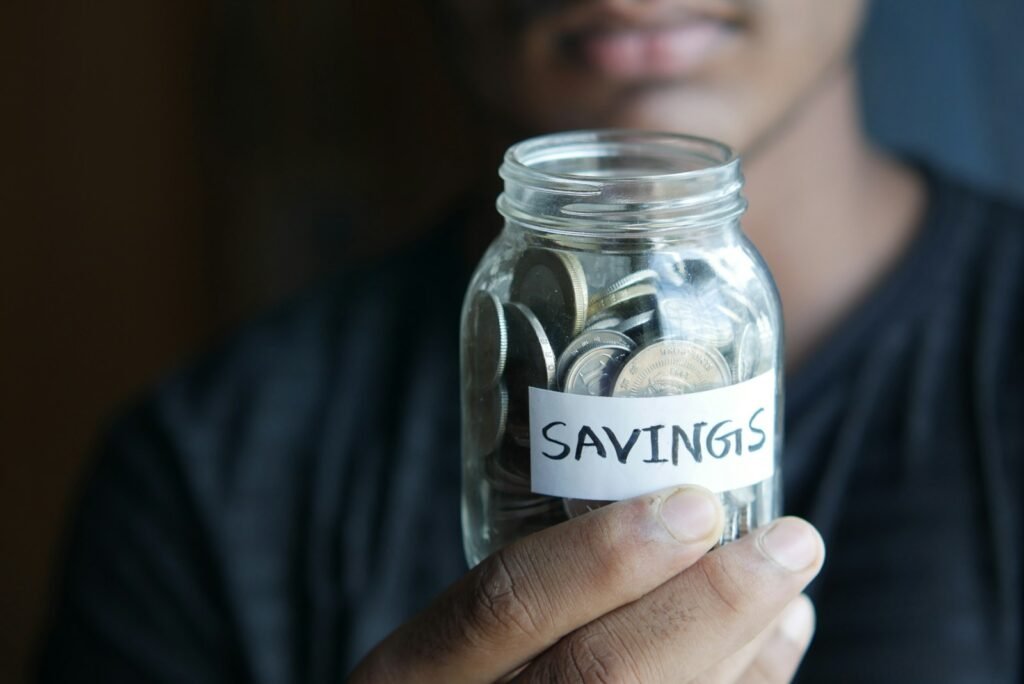 2027 HSA Contribution Limits Are Rising: What to Know Before Open Enrollment a man holding a jar with a savings label on it; 2027 HSA contribution limits