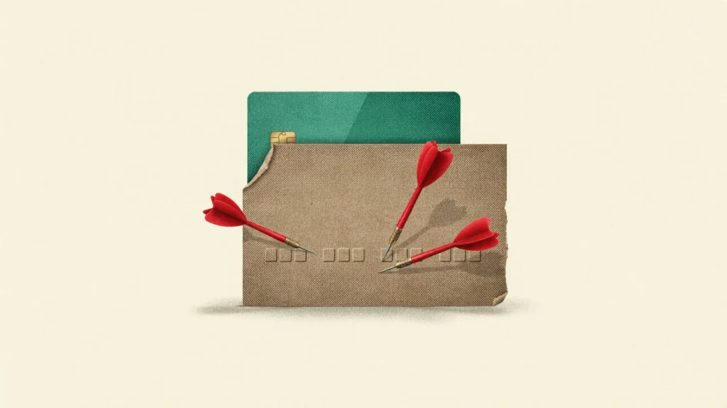 A cardboard decoy card takes three darts while the real emerald credit card stays safe behind it